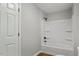 Clean bathroom boasts a bathtub with shower, white tiling, and neutral-toned walls and floors at 1844 Brier Ln, Graham, NC 27253