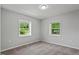 This bedroom features neutral walls, carpet, and two bright windows at 1844 Brier Ln, Graham, NC 27253