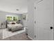 Cozy bedroom showcasing soft carpeting, a comfortable bed, and view to the lush greenery outside at 1844 Brier Ln, Graham, NC 27253