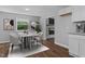 Modern dining area with seating for six, sleek decor, and an open view into the kitchen at 1844 Brier Ln, Graham, NC 27253