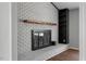 Close-up of a white-painted brick fireplace with a rustic wood mantle and built-in shelving at 1844 Brier Ln, Graham, NC 27253