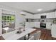 Bright kitchen and dining area featuring white cabinetry, stainless steel appliances, and hardwood floors at 1844 Brier Ln, Graham, NC 27253