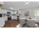 Modern kitchen with white cabinets, stainless steel appliances, and an adjacent dining area with seating for four at 1844 Brier Ln, Graham, NC 27253
