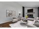 Bright living room featuring a white-painted brick fireplace, stylish decor, and an open layout for entertaining at 1844 Brier Ln, Graham, NC 27253