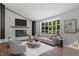 Cozy living room with white-painted brick fireplace, modern furnishings, and large windows offering natural light at 1844 Brier Ln, Graham, NC 27253