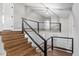 Elegant staircase with wood steps, sleek black railing, and plenty of natural light at 1844 Brier Ln, Graham, NC 27253