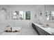 Luxurious bathroom with a soaking tub, double vanity, marble floors, and large windows for natural light at 2728 Trifle Ln, Wake Forest, NC 27587