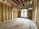Unfinished bedroom showing exposed framing, wood subfloor, and a large window opening at 2728 Trifle Ln, Wake Forest, NC 27587