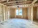 Unfinished bedroom showing exposed framing, wood subfloor, and rough openings for windows and electrical at 2728 Trifle Ln, Wake Forest, NC 27587