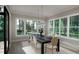 Bright dining room with large windows, modern chandelier, and a sleek black dining table with seating for six at 2728 Trifle Ln, Wake Forest, NC 27587