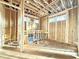 Unfinished living room showing exposed framing, wood subfloor, and rough openings for windows at 2728 Trifle Ln, Wake Forest, NC 27587