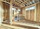 Unfinished living room showing exposed framing, wood subfloor, and rough openings for windows at 2728 Trifle Ln, Wake Forest, NC 27587