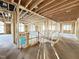Unfinished living room showing exposed framing and wood subfloor with staircase to upper level at 2728 Trifle Ln, Wake Forest, NC 27587