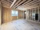 Unfinished room with wood framing, plywood flooring, a window, and exposed ceiling beams at 2728 Trifle Ln, Wake Forest, NC 27587