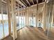 Unfinished room with wood framing, plywood flooring, a window, and exposed ceiling beams at 2728 Trifle Ln, Wake Forest, NC 27587