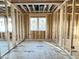 Unfinished room with wood framing, plywood flooring, a window, and exposed ceiling beams at 2728 Trifle Ln, Wake Forest, NC 27587