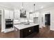 Modern kitchen features a large island, stainless steel appliances, and white shaker cabinets at 406 Terry Rd, Hillsborough, NC 27278