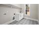 Laundry room with farmhouse sink, white cabinets, and patterned floor at 406 Terry Rd, Hillsborough, NC 27278