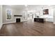 Open living room showcasing hardwood floors, kitchen island, and fireplace at 406 Terry Rd, Hillsborough, NC 27278