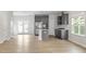 Open-concept living area with a kitchen, stainless steel appliances, gray cabinets, and hardwood floors at 9249 Kitchin Farms Way # 432, Wake Forest, NC 27587