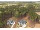 Aerial view of two newly constructed homes featuring dark roofs surrounded by a dense forest at 7440 Summer Tanager Trl, Raleigh, NC 27614