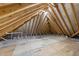 Unfinished attic displaying wooden beams and plywood flooring at 7440 Summer Tanager Trl, Raleigh, NC 27614