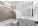 Bathroom with shower over tub, tile surround, and natural light at 7440 Summer Tanager Trl, Raleigh, NC 27614