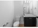 This half bathroom features a modern sink, wooden floors and a toilet at 7440 Summer Tanager Trl, Raleigh, NC 27614