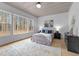 Bedroom features large windows showcasing wooded backyard and natural light at 7440 Summer Tanager Trl, Raleigh, NC 27614