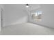 Bright bedroom with neutral carpeting, dormer window, and fresh neutral paint at 7440 Summer Tanager Trl, Raleigh, NC 27614