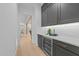 The butler pantry features gray cabinets with gold hardware, and a wine fridge at 7440 Summer Tanager Trl, Raleigh, NC 27614