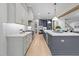 An open-concept kitchen features two-tone cabinets, designer lighting, and an island with seating at 7440 Summer Tanager Trl, Raleigh, NC 27614