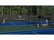 Two tennis players on a well maintained tennis court with a shaded rest area at 7440 Summer Tanager Trl, Raleigh, NC 27614