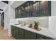 Wet bar with green cabinets, a quartz countertop, and gold accents at 7645 Falls Creek Ln, Raleigh, NC 27614