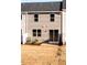 Exterior view of the back of the townhome, including the sliding glass door, windows, and lawn at 187 Pinkie Ln, Garner, NC 27529