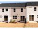 Exterior view of the back of the townhomes with sliding glass doors and small lawns at 187 Pinkie Ln, Garner, NC 27529