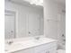 Bright bathroom featuring a double sink vanity, large mirror, and shower-tub combination with white tile surround at 187 Pinkie Ln, Garner, NC 27529