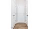Hallway view featuring a wood floor with a series of white paneled doors at 187 Pinkie Ln, Garner, NC 27529