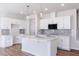 Modern kitchen with white cabinets, gray backsplash, stainless steel appliances, and a kitchen island at 187 Pinkie Ln, Garner, NC 27529