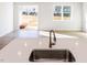 Open concept kitchen with stainless steel sink, island, and view of the outdoor space through a sliding glass door at 187 Pinkie Ln, Garner, NC 27529