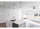 A bright kitchen with an island connects to the living room with a ceiling fan and sliding glass door access at 187 Pinkie Ln, Garner, NC 27529