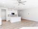 Bright and spacious living area with a kitchen island and stainless steel appliances, with views of the staircase at 187 Pinkie Ln, Garner, NC 27529