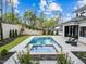 A backyard with a modern pool, spa, patio, and lush landscaping at 861 Wimbleton Dr, Raleigh, NC 27609