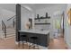 Chic bar area with counter seating, open shelving, and view of staircase at 861 Wimbleton Dr, Raleigh, NC 27609