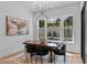 Elegant dining room with a modern chandelier and a view of the pool area through large windows at 861 Wimbleton Dr, Raleigh, NC 27609