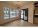 Bright dining room featuring modern chandelier, light wood floors, and views of the outdoor pool area at 861 Wimbleton Dr, Raleigh, NC 27609