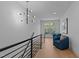 Bright hallway with modern lighting, staircase, and cozy sitting area by the window at 861 Wimbleton Dr, Raleigh, NC 27609