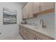 Well-appointed laundry room featuring custom cabinets, quartz countertops, and stylish tile flooring at 861 Wimbleton Dr, Raleigh, NC 27609