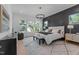 Bright main bedroom with a large bed, an accent wall, and windows offering a view of the landscaped backyard at 861 Wimbleton Dr, Raleigh, NC 27609