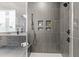 Contemporary walk-in shower with gray textured tile, built-in bench, and matte black hardware at 861 Wimbleton Dr, Raleigh, NC 27609